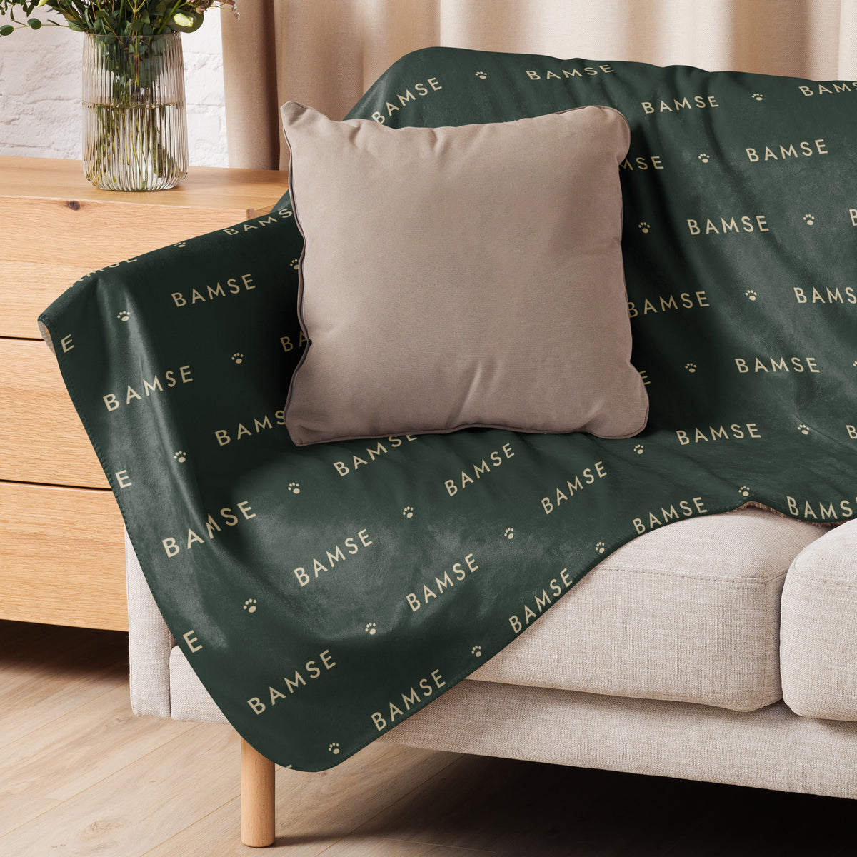 Sherpafilt i Skog med namnet Bamse i ett mönster, draperad över en soffa